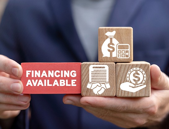a person holding building blocks with finance-themed graphics on them