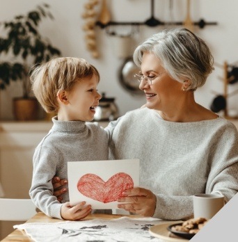 Older woman smiling at grandchild after coloring together