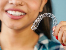 Nose-to-neck view of woman holding Invisalign tray