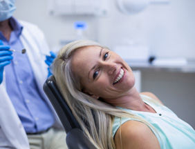 Woman smiling while sitting in dentist treatment chair