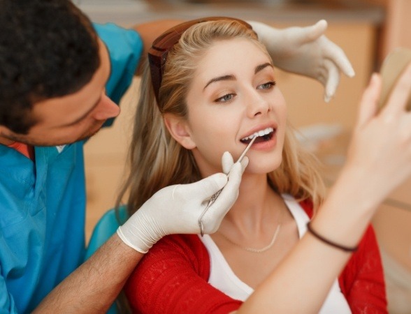 Woman with porcelain veneers looking at her beautiful smile