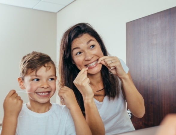 Mother and child flossing teeth to prevent dental emergencies