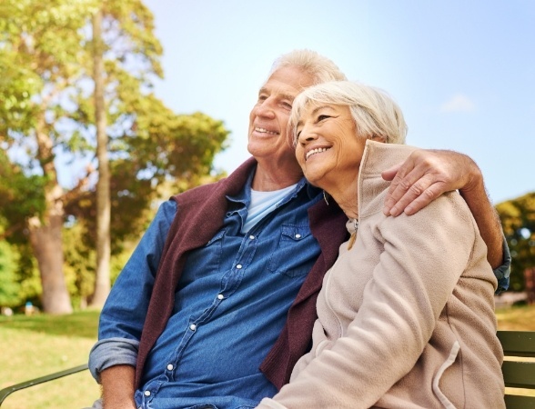 Man and woman smiling after dental implant tooth replacement