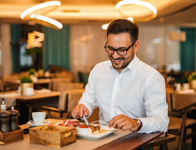 Man smiling while enjoying meal at restaurant