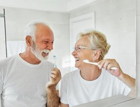 a mature couple brushing and caring for their dental implants 