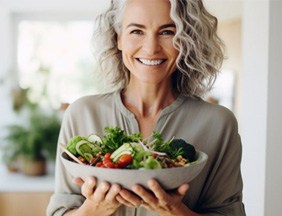 a woman holding a bowl of healthy foods
