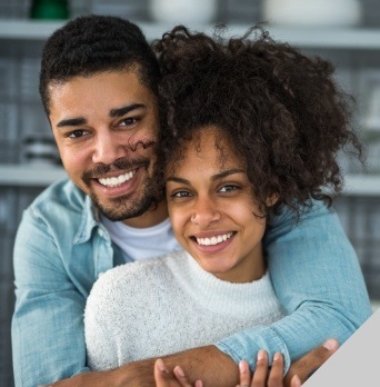 Young man hugging woman from behind