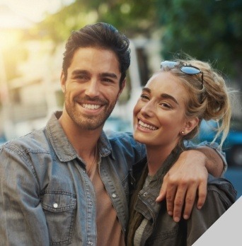 Man and woman smiling outdoors on city street