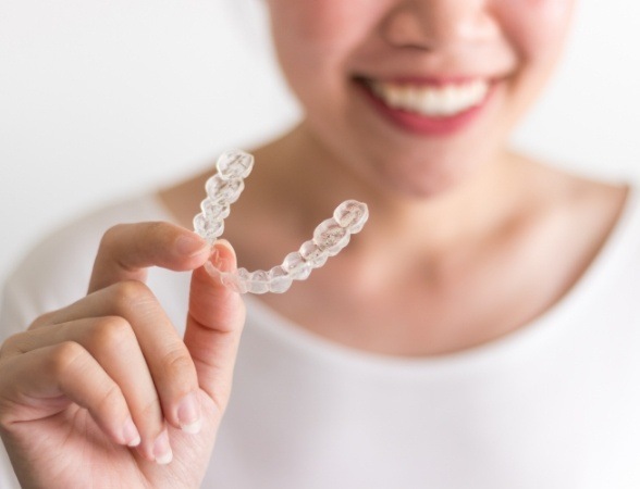 Woman holding an Invisalign tray