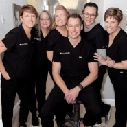 The team at Dr. Davis Dental Care, led by Anthony Dillard, DDS, smiles together in a professional setting.