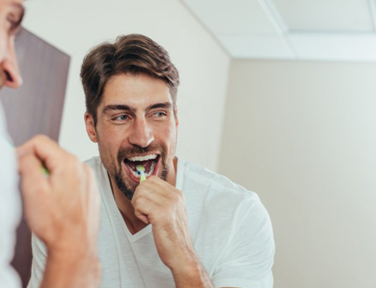 a man brushing his teeth at home in the morning