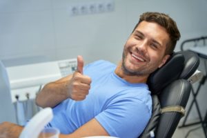 Male dental patient making thumbs-up gesture
