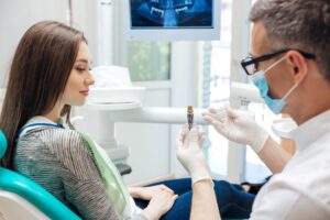 Dentist explaining dental implants to woman with brown hair