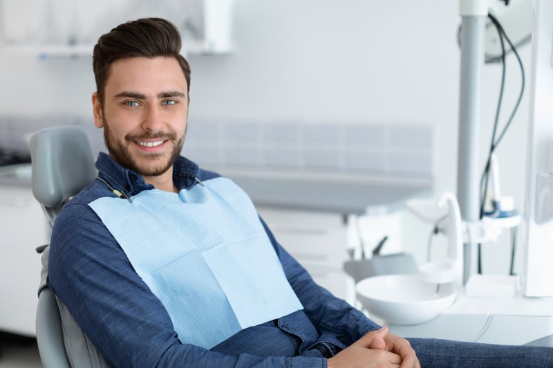 a dental patient smiling while visiting the dentist